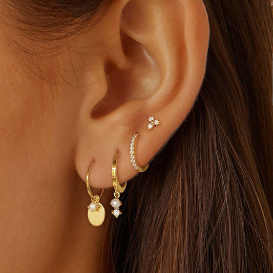 Gold earring set for women including huggie hoops, pearl dangle and stackable minimalist earrings, trendy jewelry flat lay